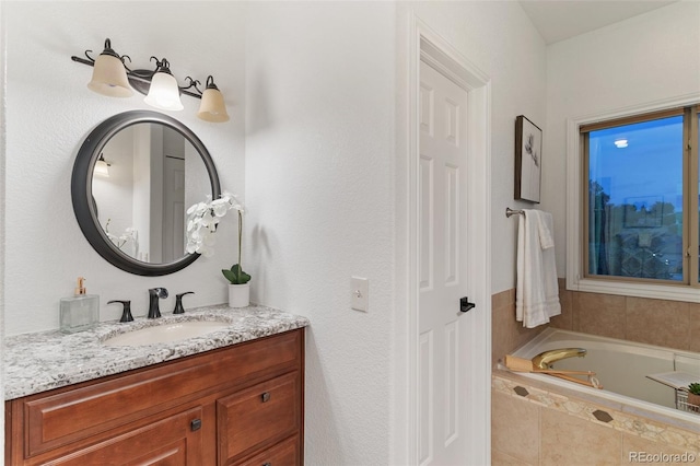 bathroom with tiled bath and vanity