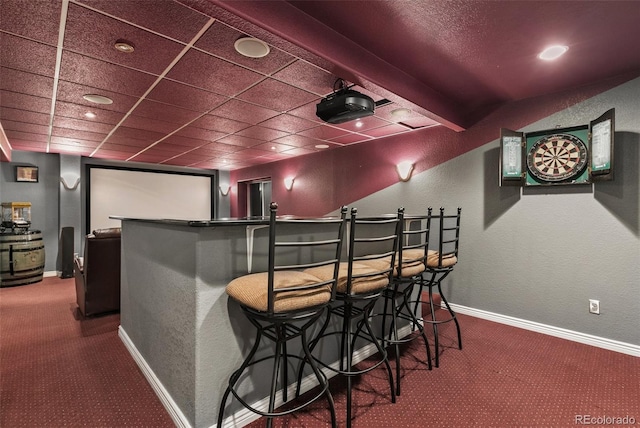 carpeted home theater room with bar