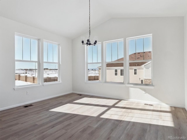 unfurnished dining area featuring hardwood / wood-style floors, lofted ceiling, and a notable chandelier