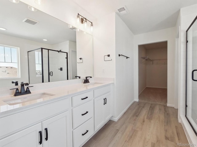 bathroom featuring vanity, hardwood / wood-style flooring, and an enclosed shower