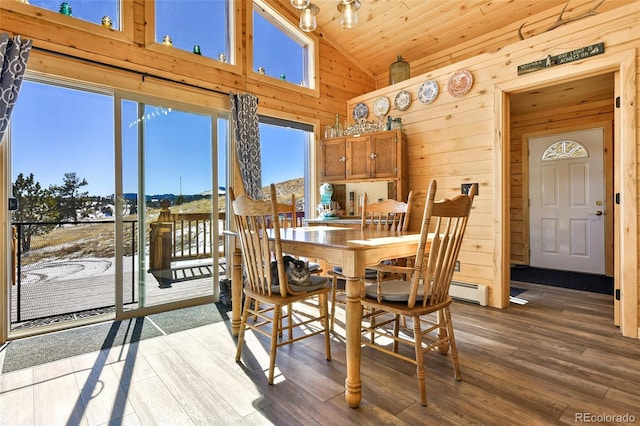 dining area featuring wood finished floors, wooden walls, wood ceiling, and high vaulted ceiling