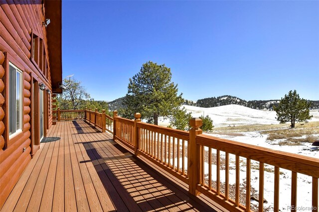 snow covered deck with a mountain view