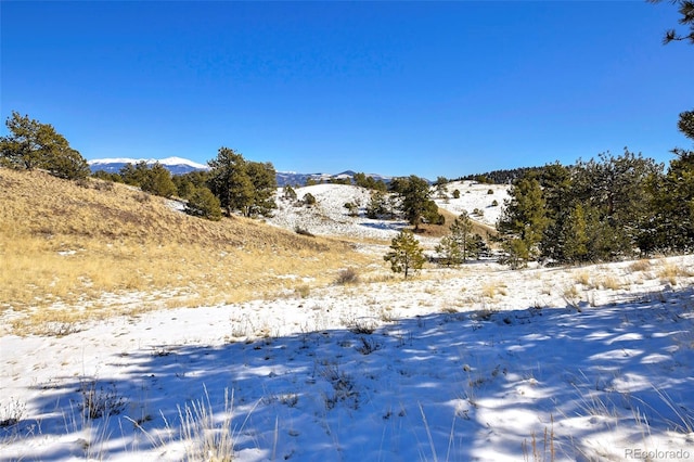 view of snow covered land featuring a mountain view