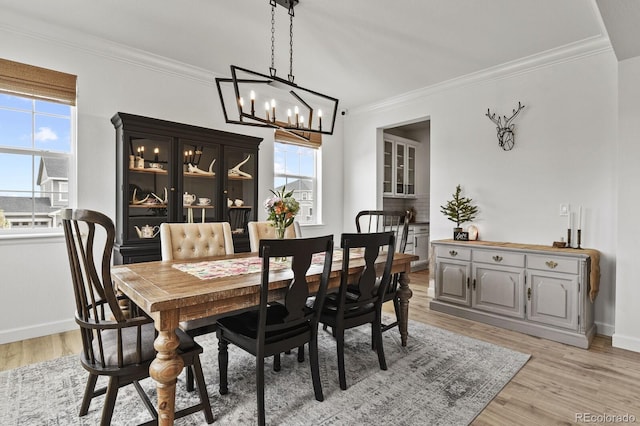 dining room featuring a notable chandelier, crown molding, and light hardwood / wood-style flooring