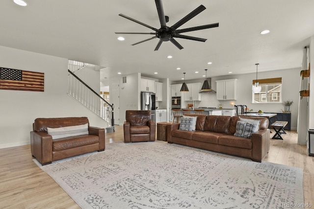 living room with ceiling fan and light hardwood / wood-style floors