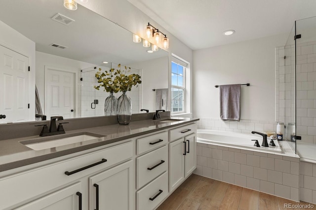 bathroom with vanity, wood-type flooring, and shower with separate bathtub