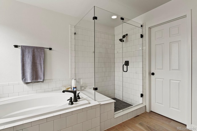 bathroom featuring hardwood / wood-style flooring and plus walk in shower