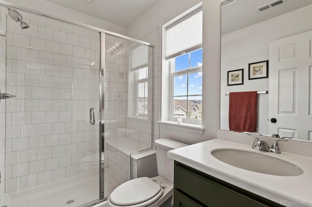 bathroom with walk in shower, vanity, and toilet