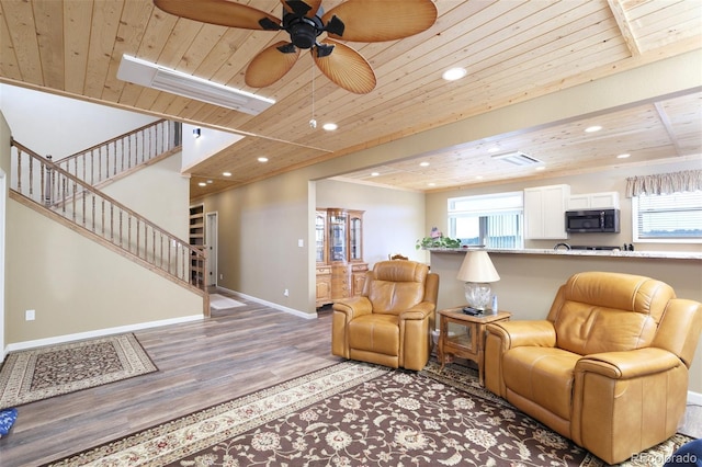 living room with light wood finished floors, a wealth of natural light, wood ceiling, and baseboards