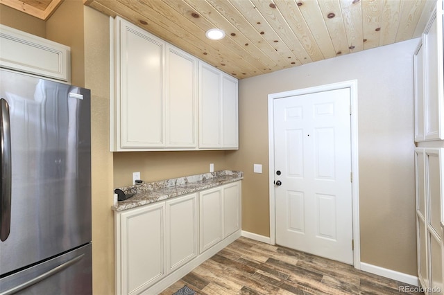 kitchen with wooden ceiling, stainless steel fridge, baseboards, and wood finished floors