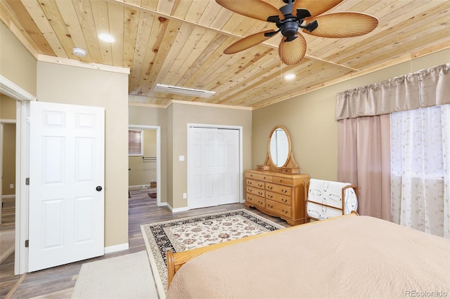 bedroom featuring a closet, wood ceiling, baseboards, and wood finished floors