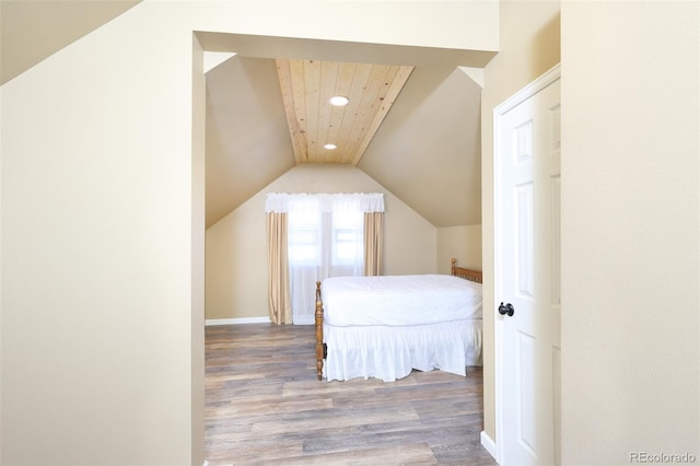 bedroom featuring lofted ceiling, wood finished floors, and recessed lighting