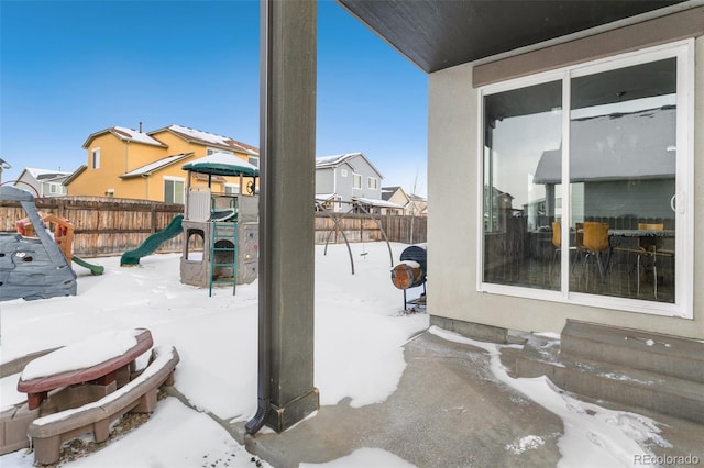 snow covered patio with a playground