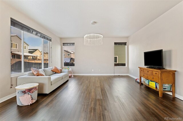 living room featuring an inviting chandelier and dark hardwood / wood-style floors