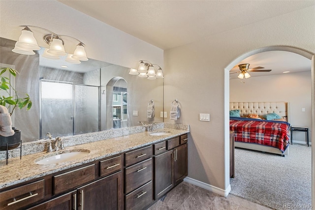 bathroom with ceiling fan, vanity, and a shower with door