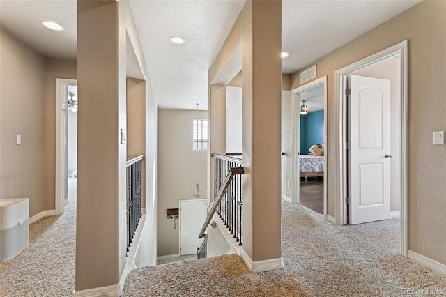 hallway featuring light colored carpet