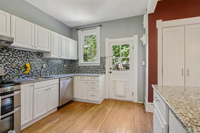 351 Bannock St, Denver, CO 80223 - kitchen with stainless steel appliances, backsplash, and white cabinetry