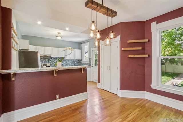 351 Bannock St, Denver, CO 80223 - kitchen with a breakfast bar area, freestanding refrigerator, and plenty of natural light