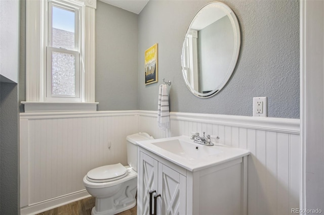 351 Bannock St, Denver, CO 80223 - half bath featuring a wainscoted wall, vanity, and wood finished floors