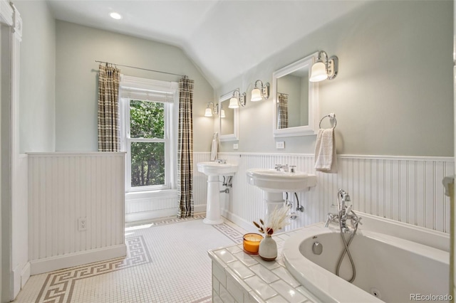 351 Bannock St, Denver, CO 80223 - bathroom featuring a bath, vaulted ceiling, and a wainscoted wall