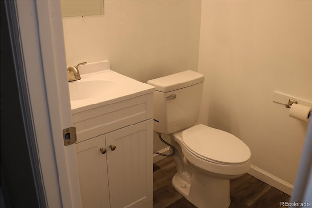 bathroom with hardwood / wood-style floors, vanity, and toilet