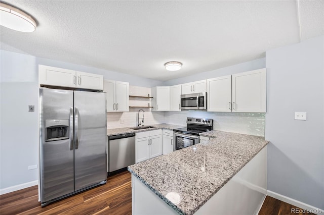 610 S Alton Way Unit 7C, Denver, CO 80247 - kitchen with stainless steel appliances, white cabinets, a peninsula, open shelves, and light stone countertops