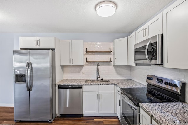610 S Alton Way Unit 7C, Denver, CO 80247 - kitchen featuring stainless steel appliances, dark wood-style flooring, open shelves, light stone countertops, and white cabinets