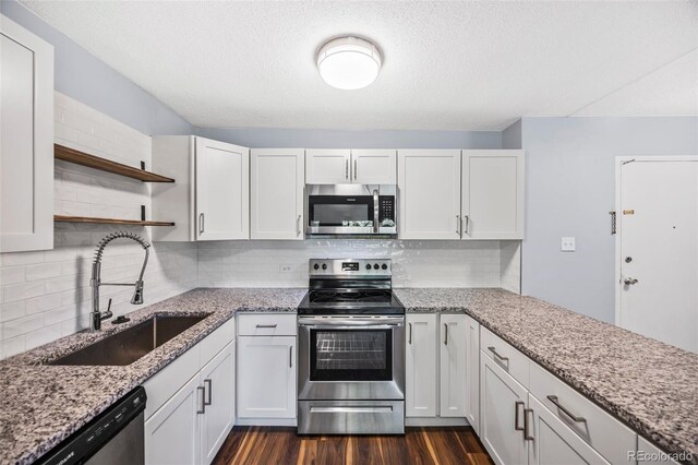 610 S Alton Way Unit 7C, Denver, CO 80247 - kitchen featuring stainless steel appliances, open shelves, dark wood-type flooring, white cabinetry, and a textured ceiling