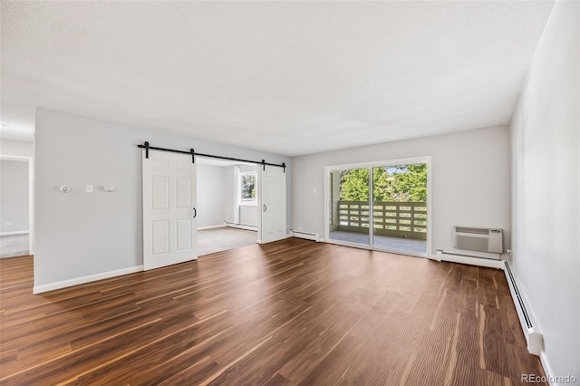 610 S Alton Way Unit 7C, Denver, CO 80247 - unfurnished room featuring a barn door, a baseboard heating unit, wood finished floors, and a wall mounted air conditioner