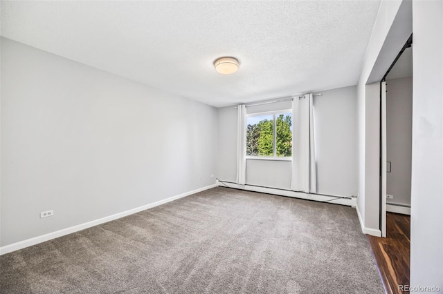 610 S Alton Way Unit 7C, Denver, CO 80247 - spare room featuring a baseboard radiator, a textured ceiling, and carpet floors