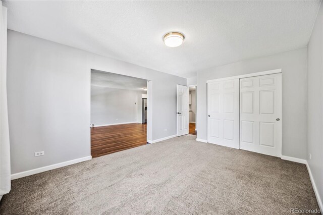 610 S Alton Way Unit 7C, Denver, CO 80247 - unfurnished bedroom featuring carpet flooring, a closet, and a textured ceiling