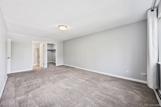 610 S Alton Way Unit 7C, Denver, CO 80247 - unfurnished bedroom featuring carpet, a textured ceiling, a walk in closet, and a closet