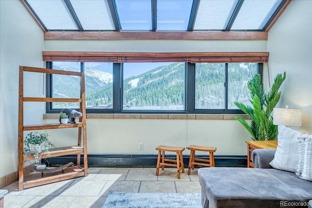 189 Ten Mile Cir Unit 551, Frisco, CO 80443 - living area featuring stone tile flooring, a mountain view, a skylight, and baseboards