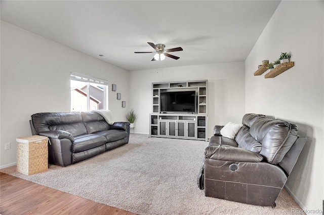 living room featuring wood-type flooring and ceiling fan