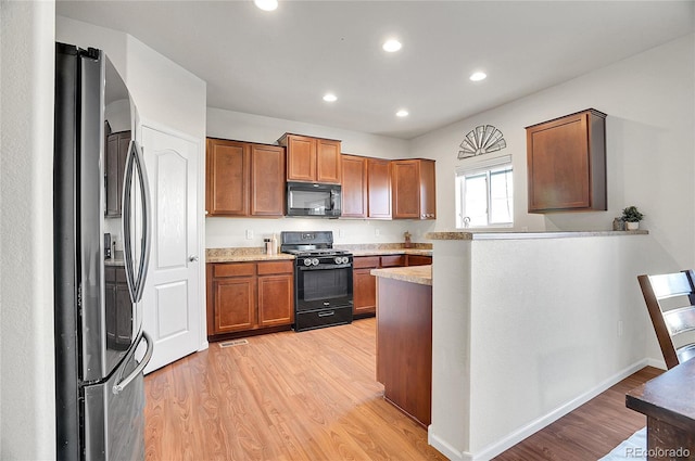 kitchen with light wood-type flooring and black appliances