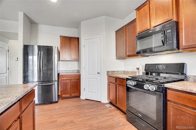 kitchen featuring light hardwood / wood-style flooring and black appliances