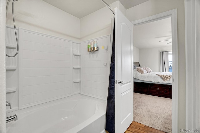 bathroom with wood-type flooring and bathing tub / shower combination