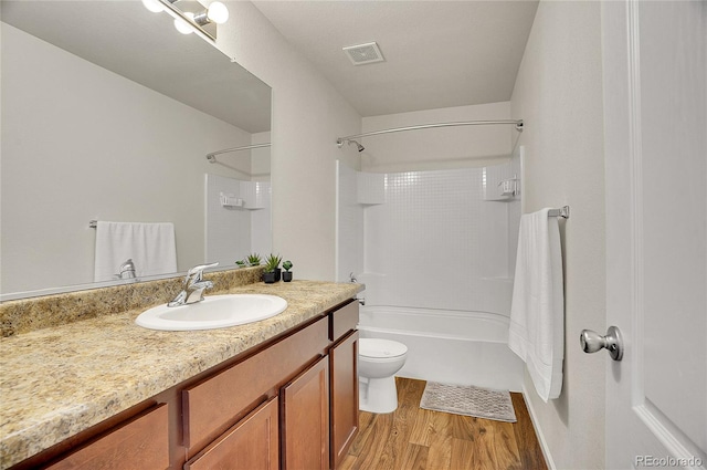 full bathroom featuring vanity, hardwood / wood-style floors, shower / bathtub combination, and toilet