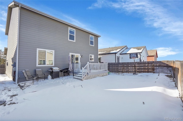 snow covered house with a deck