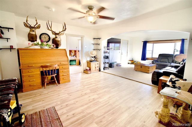 7013 County Road 69, Keenesburg, CO 80643 - living area with arched walkways, light wood-style floors, and a ceiling fan