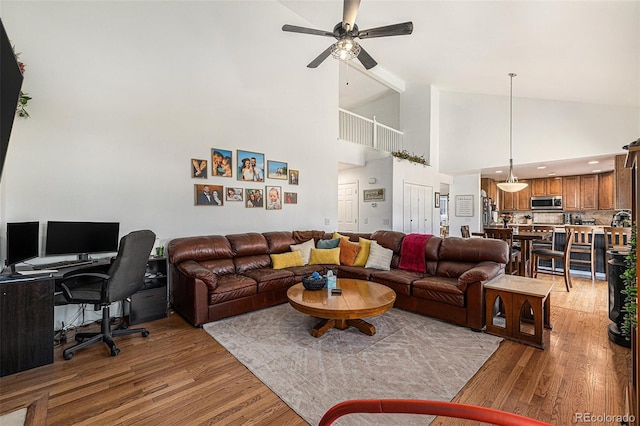 17464 Crestview Ct, Monument, CO 80132 - living room with light wood-style flooring, a ceiling fan, an office area, and high vaulted ceiling