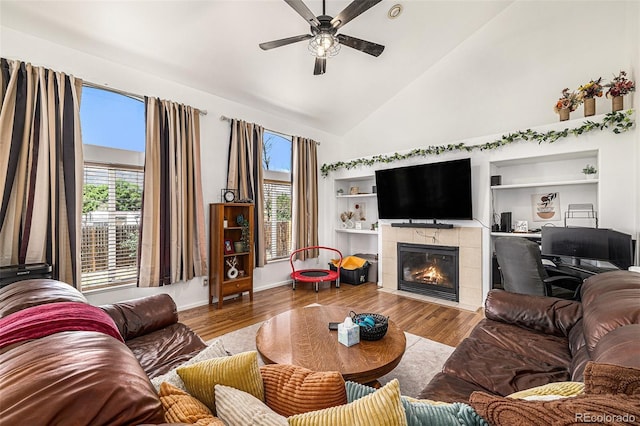 17464 Crestview Ct, Monument, CO 80132 - living area with a ceiling fan, healthy amount of natural light, a tiled fireplace, wood finished floors, and high vaulted ceiling