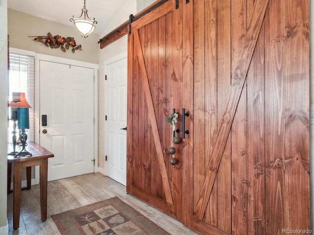 foyer entrance featuring a barn door and light wood-type flooring