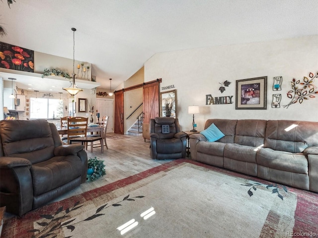 living area with lofted ceiling and a barn door