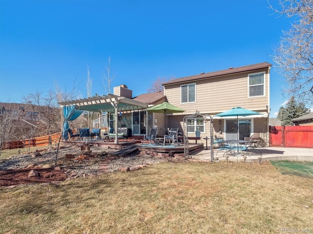 back of house with a patio, fence, a lawn, a pergola, and a chimney