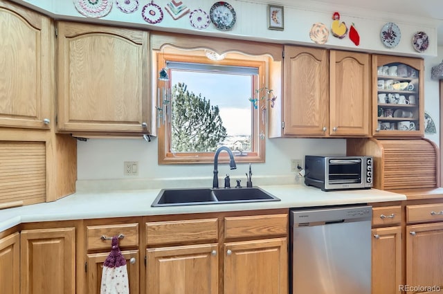 kitchen featuring light countertops, stainless steel dishwasher, a sink, and a toaster