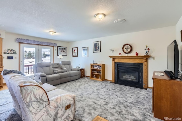 carpeted living room with a glass covered fireplace, french doors, a textured ceiling, and baseboards