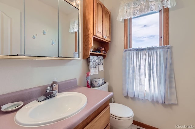 half bath featuring vanity and toilet