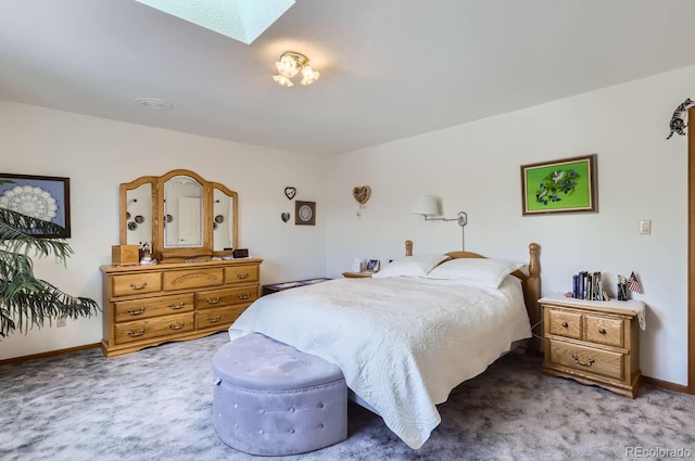 carpeted bedroom featuring a skylight and baseboards