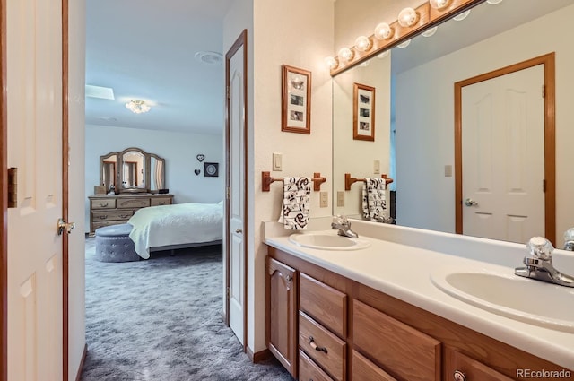 bathroom with ensuite bathroom, double vanity, and a sink